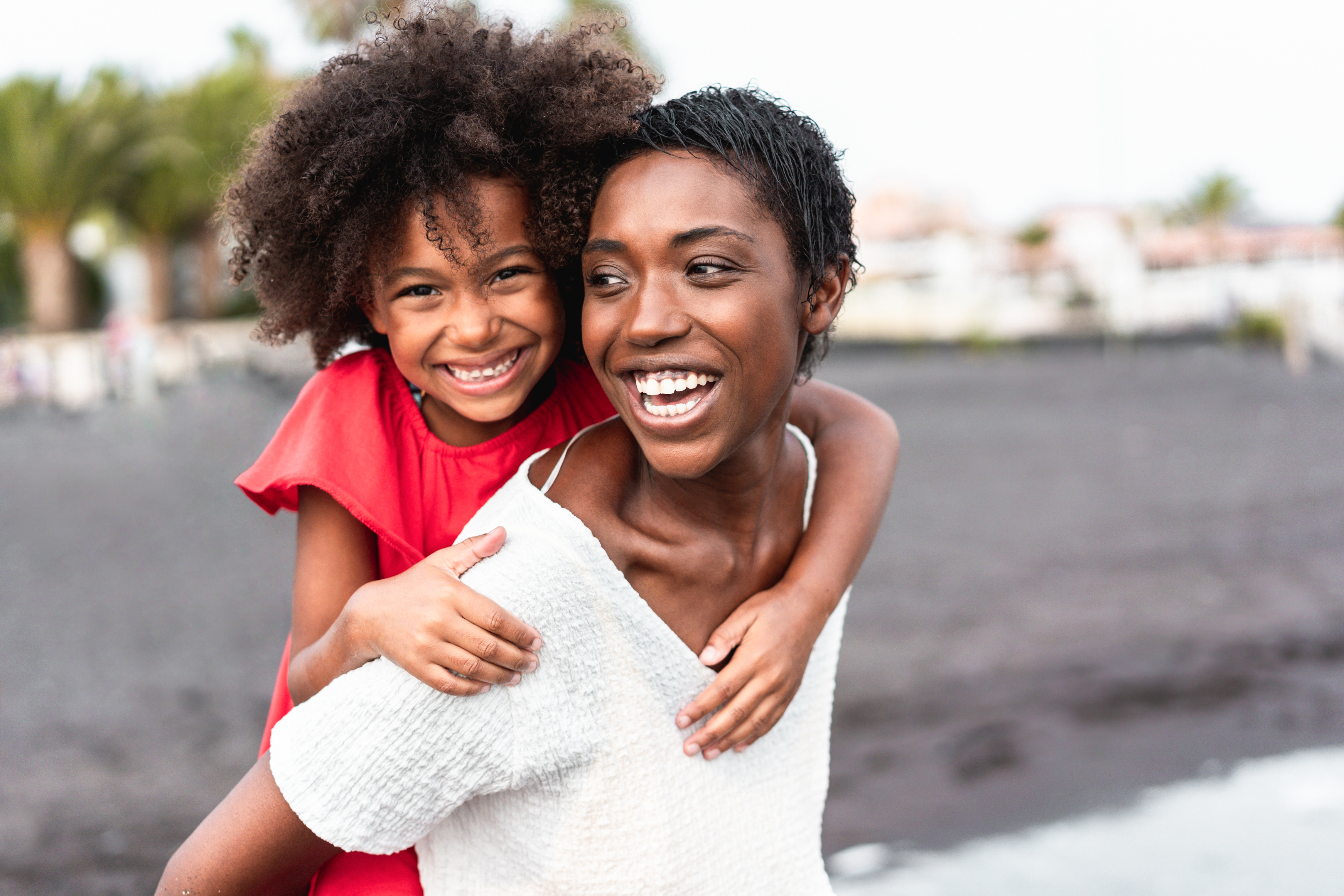 African-American mother and daughter having fun on the beach – Family people laughing together outdoor – Focus on mom’s face AdobeStock 380887815 1