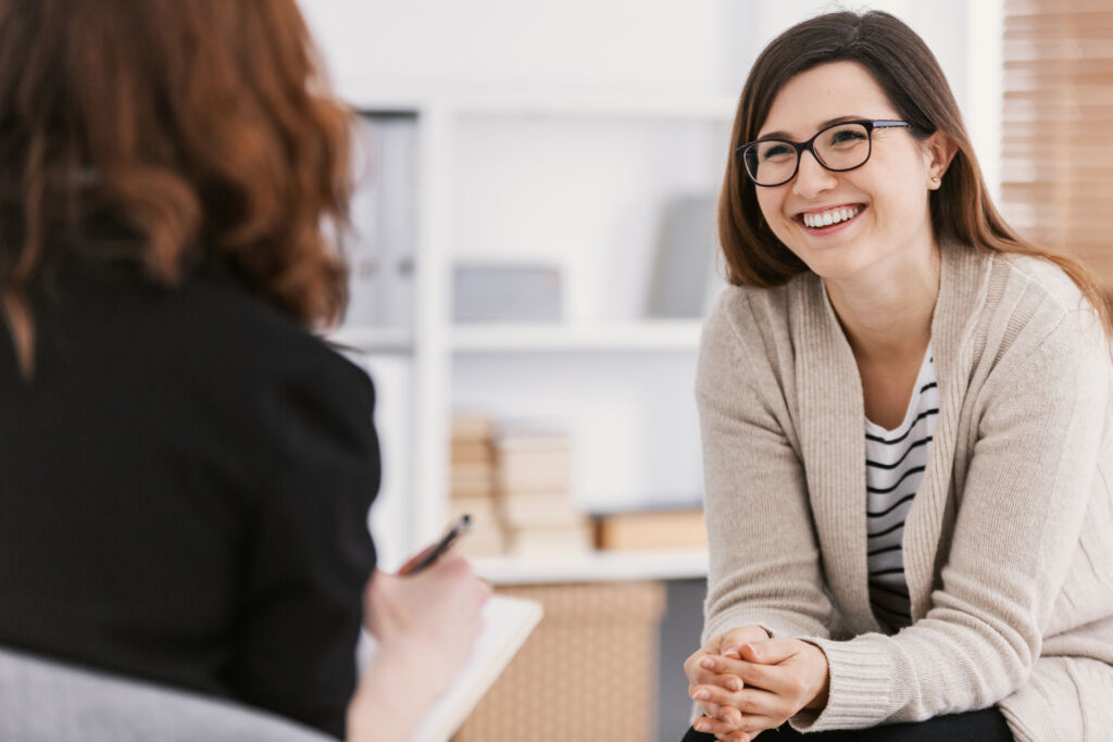 Happy woman speaking to addiction treatment specialist