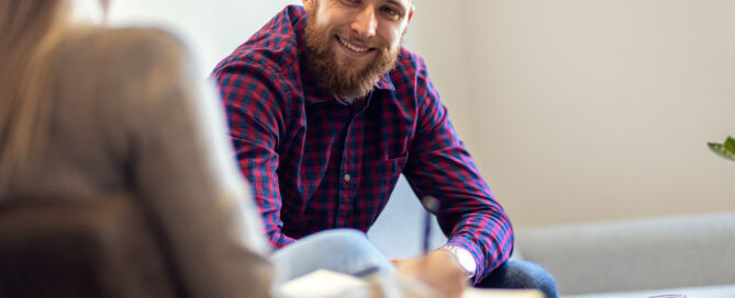 Young man talking to female psychologist during session