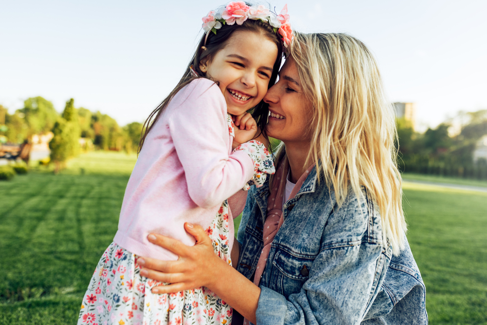 Closeup outdoor portrait of happy mom with her daughter.