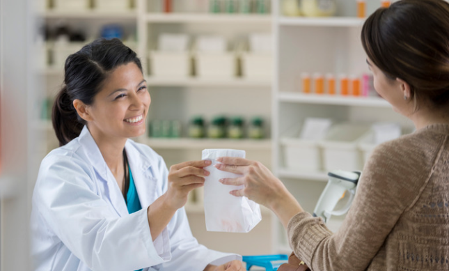Pharmacist smiling patient A medical professional in a welcoming Suboxone clinic setting, ready to prescribe buprenorphine and support patients seeking addiction treatment.