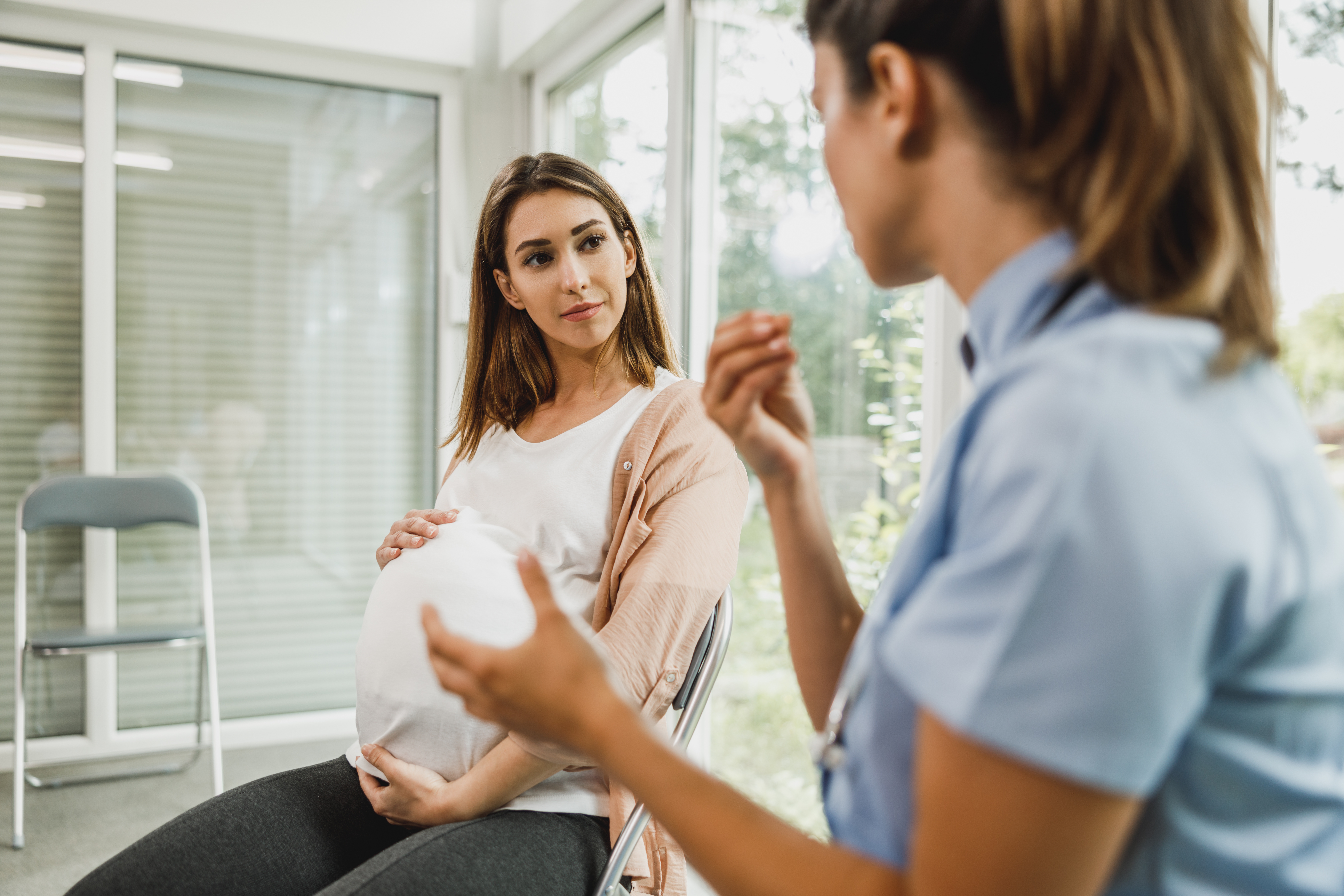 pregnant woman talking to addiction treatment specialist