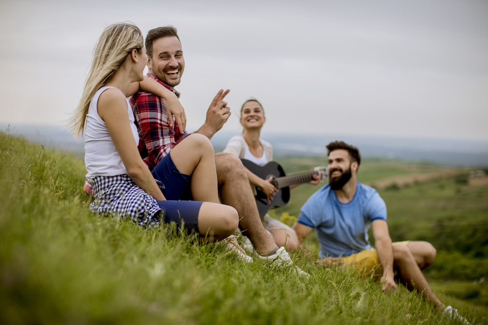 Group of young people sitting on grass.