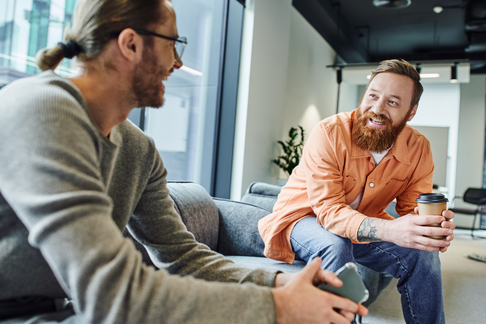 Support system at drug rehab centers, like peer connections - Two men happily talking about addiction recovery