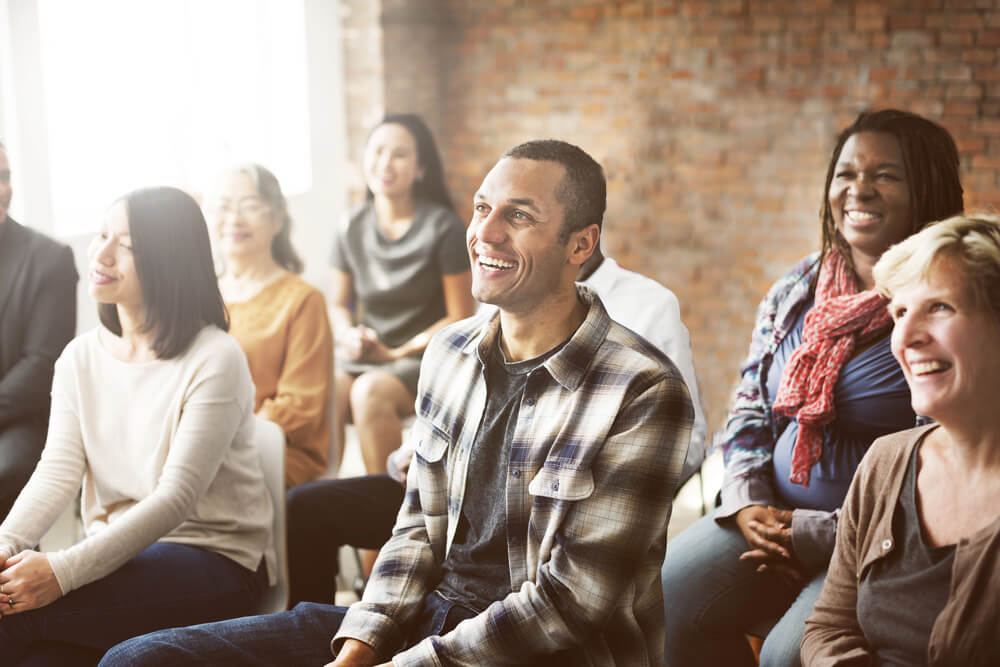 A diverse group of individuals engaging in a supportive discussion, sharing experiences and encouragement related to methadone treatment for opioid addiction.