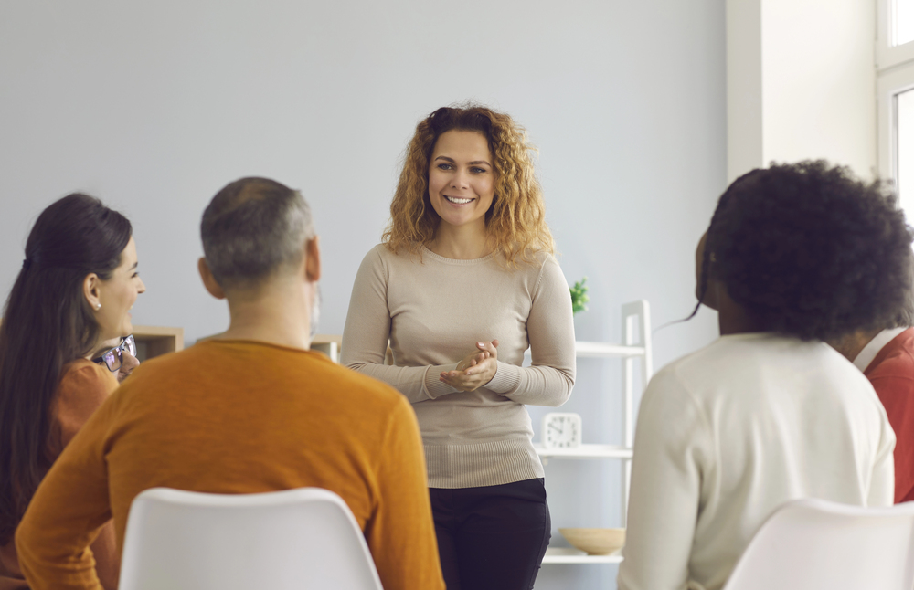 A group therapy session, possibly related to buprenorphine treatment, with a woman leading the discussion.