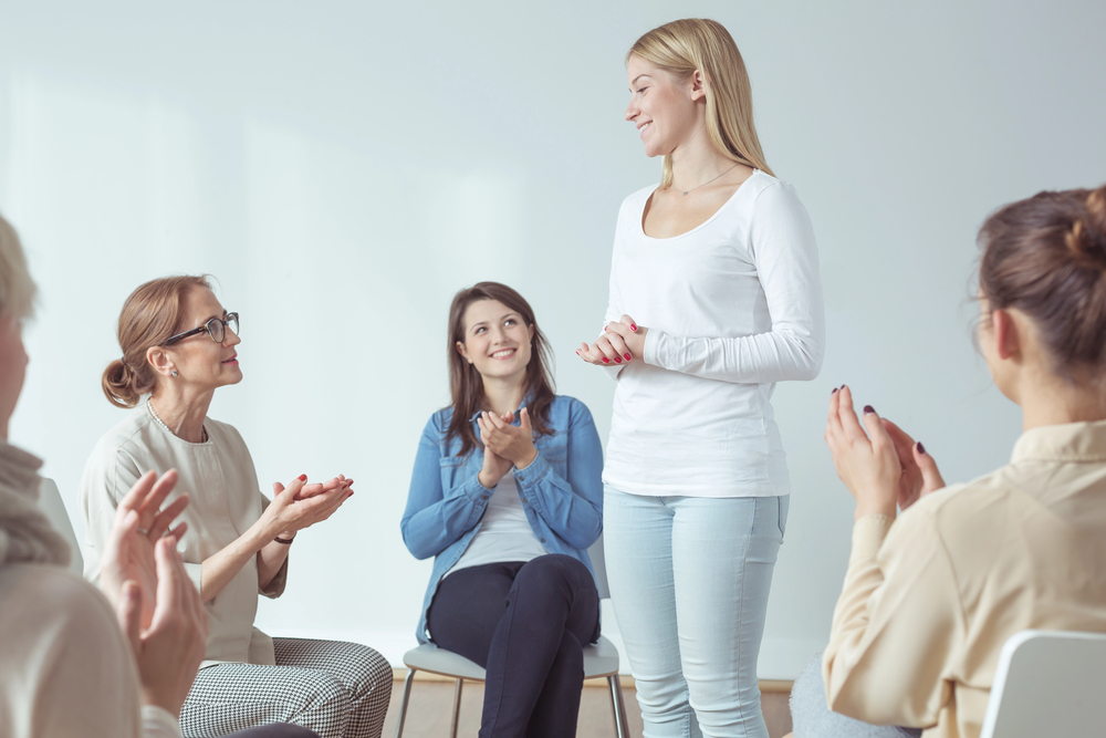 Participants engage in a group therapy session, a key component of a treatment program for substance use disorders.